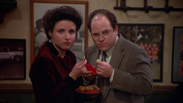 Julia Louis-Dreyfus and Jason Alexander as Elaine and George standing together on Seinfeld