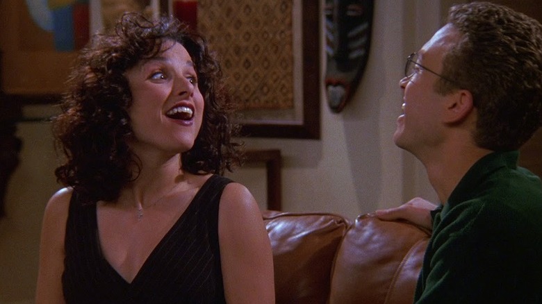 Julia Louis-Dreyfus as Elaine smiling at Samuel Bliss Cooper as Darryl in Seinfeld