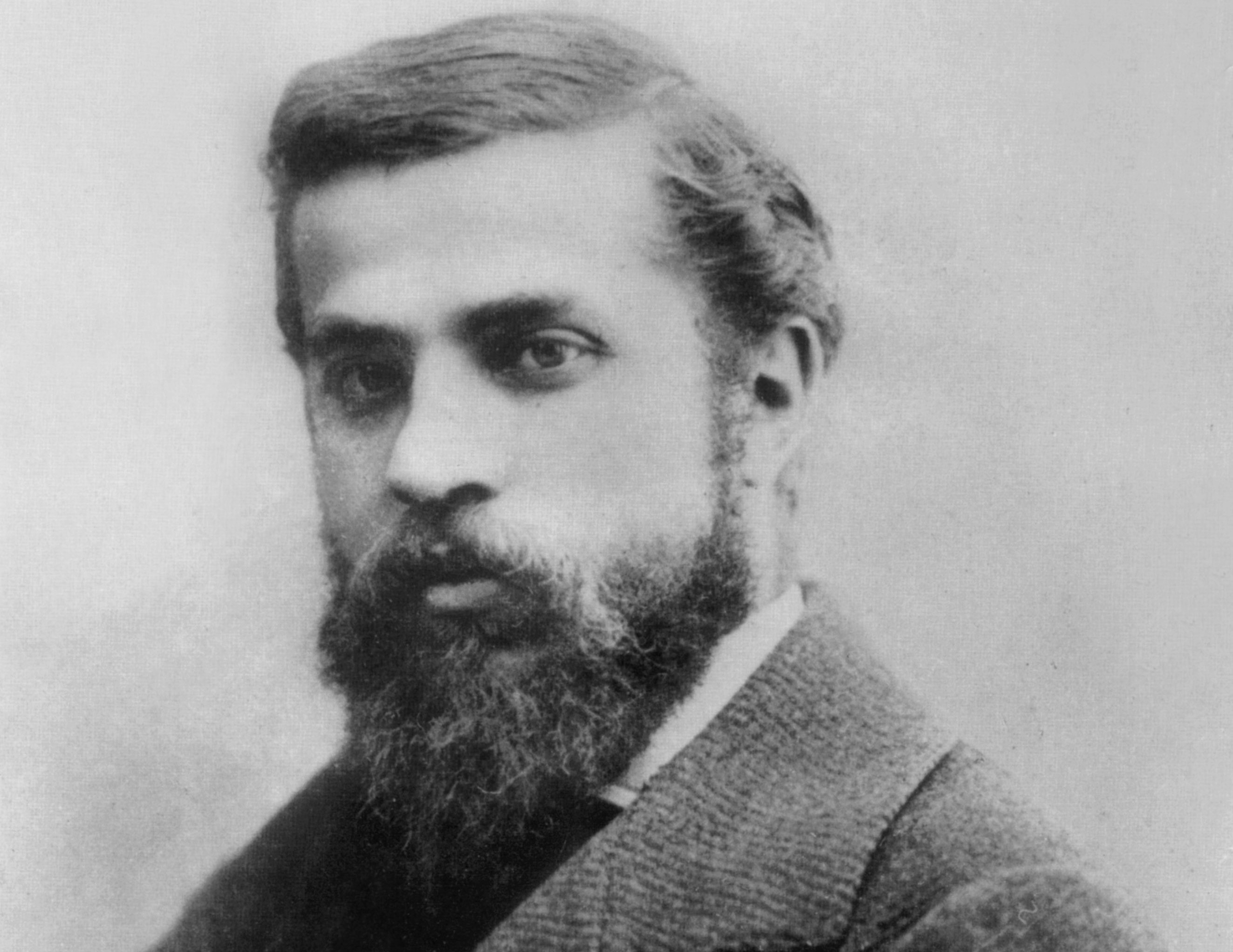 Portrait of Catalan architect Antoni Gaudi with a beard and mustache, wearing a coat.