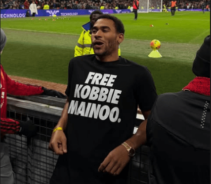 Jordan Mainoo-Hames wearing a "FREE KOBBIE MAINOO" t-shirt at a Manchester United v Bournemouth match.