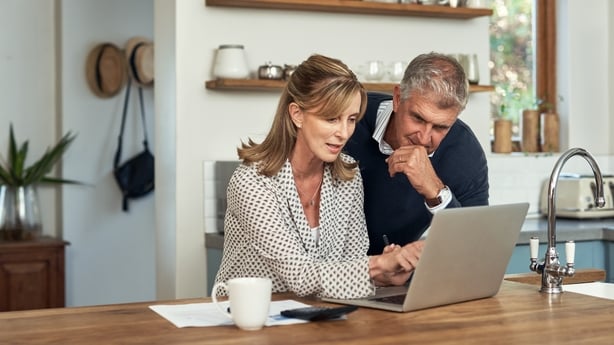 A senior couple using a laptop at home.