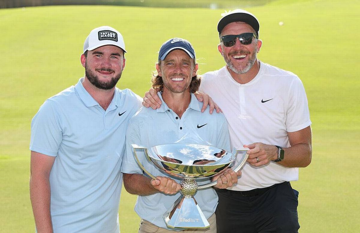 Tommy Fleetwood poses with the Fedex Cup trophy, his stepson, Oscar Craig, and caddie, Ian Finnis
