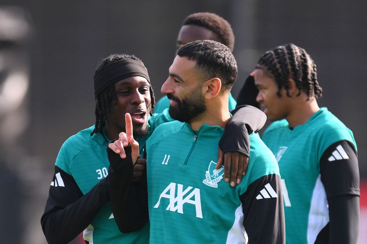 Jeremie Frimpong of Liverpool reacts with team-mate Mohamed Salah at AXA Training Centre on September 29 2025