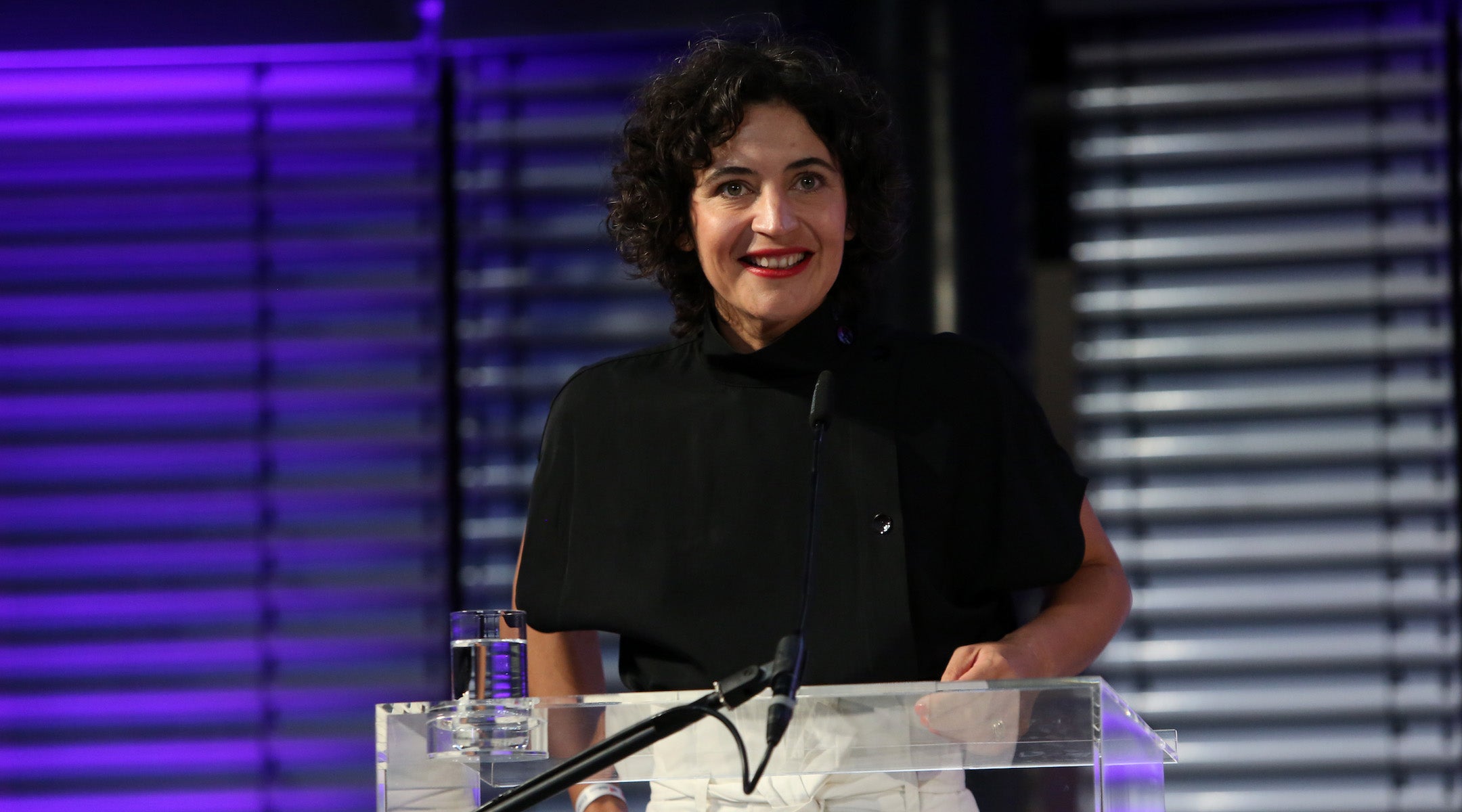 A woman receives an award at a podium