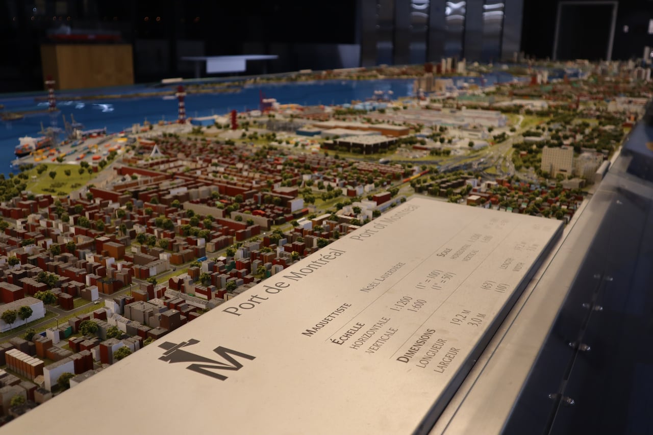 A silver plaque sits in front of a large diorama showing Montreal and all the different terminals. The plaque reads 'Port of Montreal' and shows the dimensions of the diorama.
