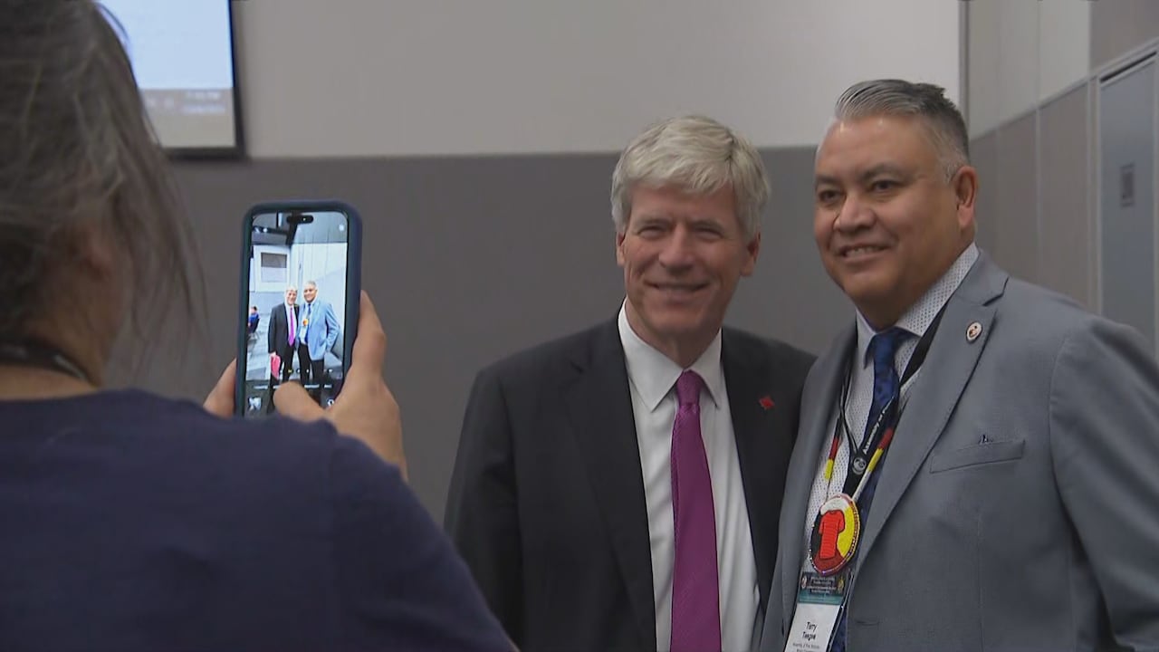 B.C. Regional Chief Terry Teegee gets a photo with Minister Tim Hodgson in a board room, with a cell phone visible and the photo on it.