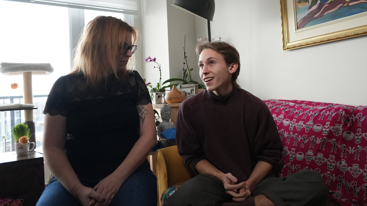 A woman and a young man sit next to eachother 