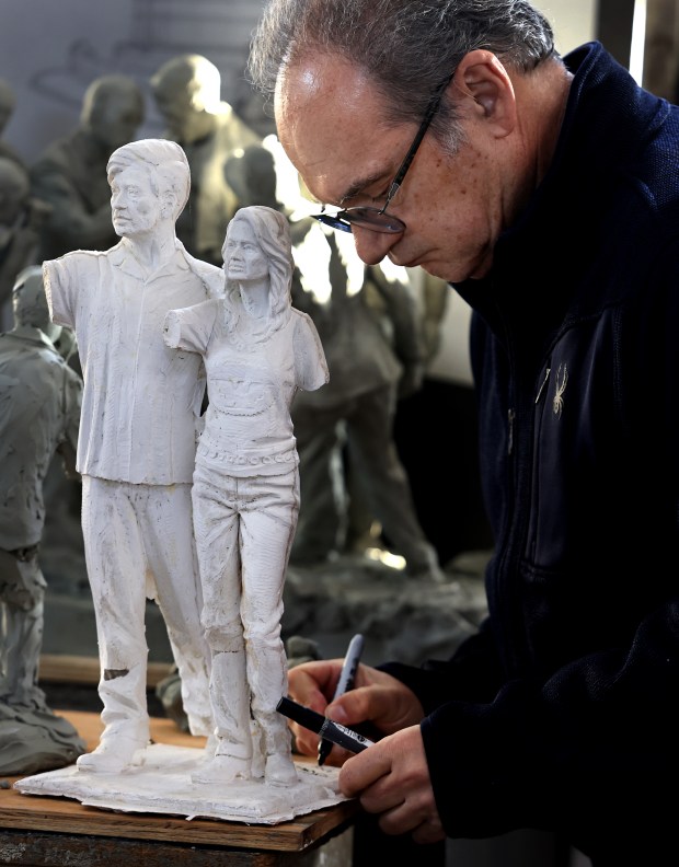 Artist Mario Chiodo signs the original artists proof of Cesar Chavez and Dolores Huerta before presenting it to Mia Alonso Mendez, Wednesday, Dec. 17, 2025, in Napa. (Kent Porter / The Press Democrat)