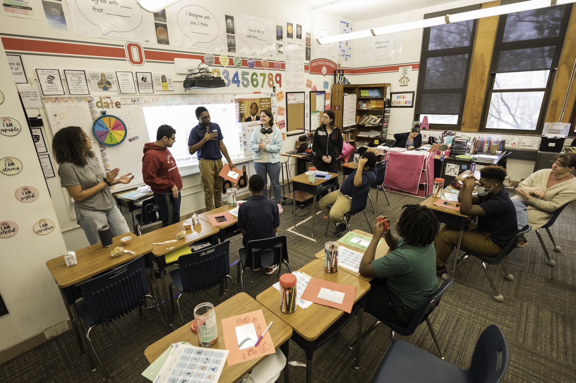 l-r: Zoë Miles ’25 (T5), Sree Chatterjee ’26, Jenna Savino ’26, and Maddie Bellamy ’27 are pictured with RP student Marquez Smith (C) as students present their work at the end of class. 