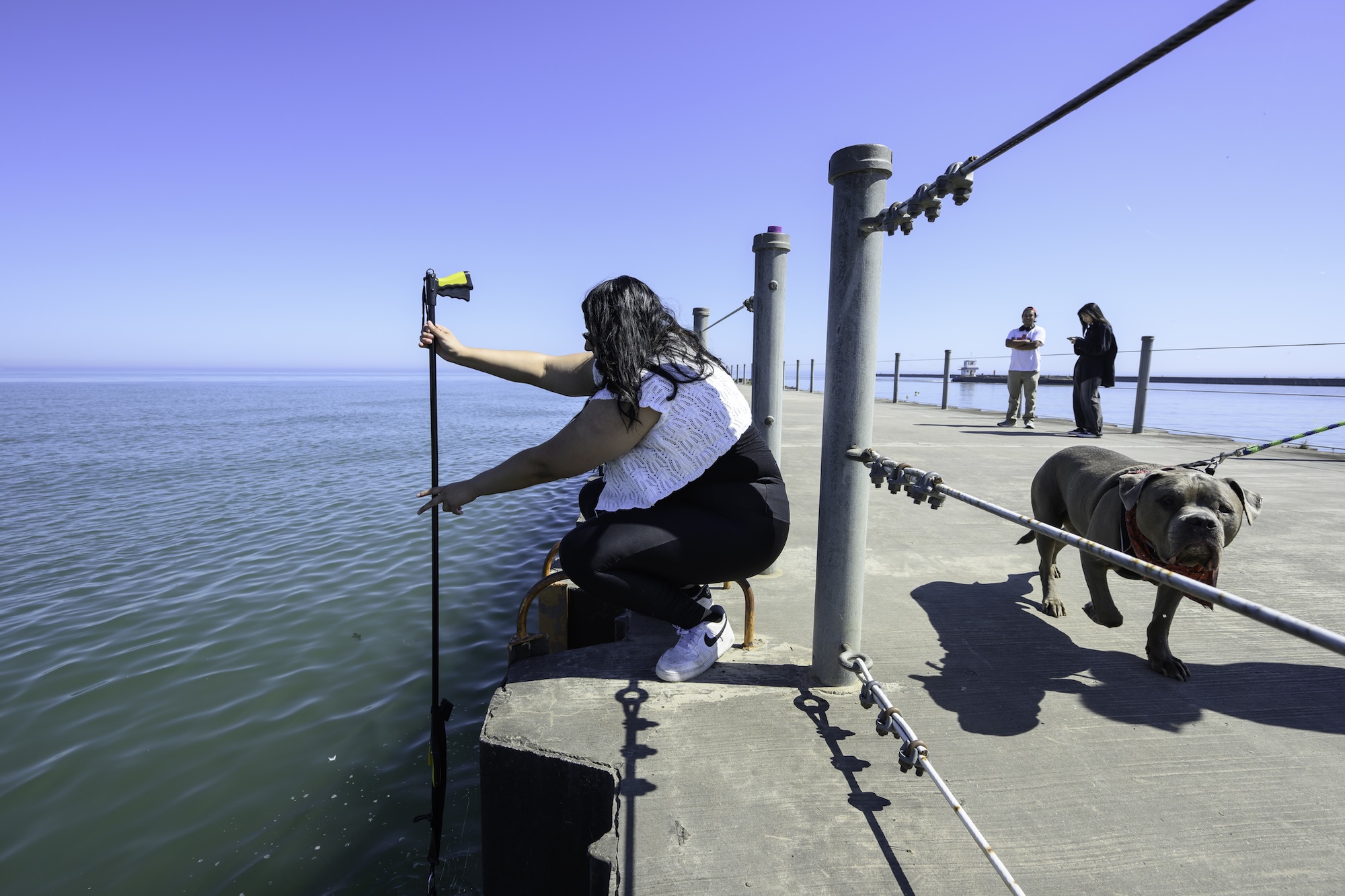 Toxicology Ph.D. Candidate Alma Avila Oropeza etrieves a sample jar from the water.