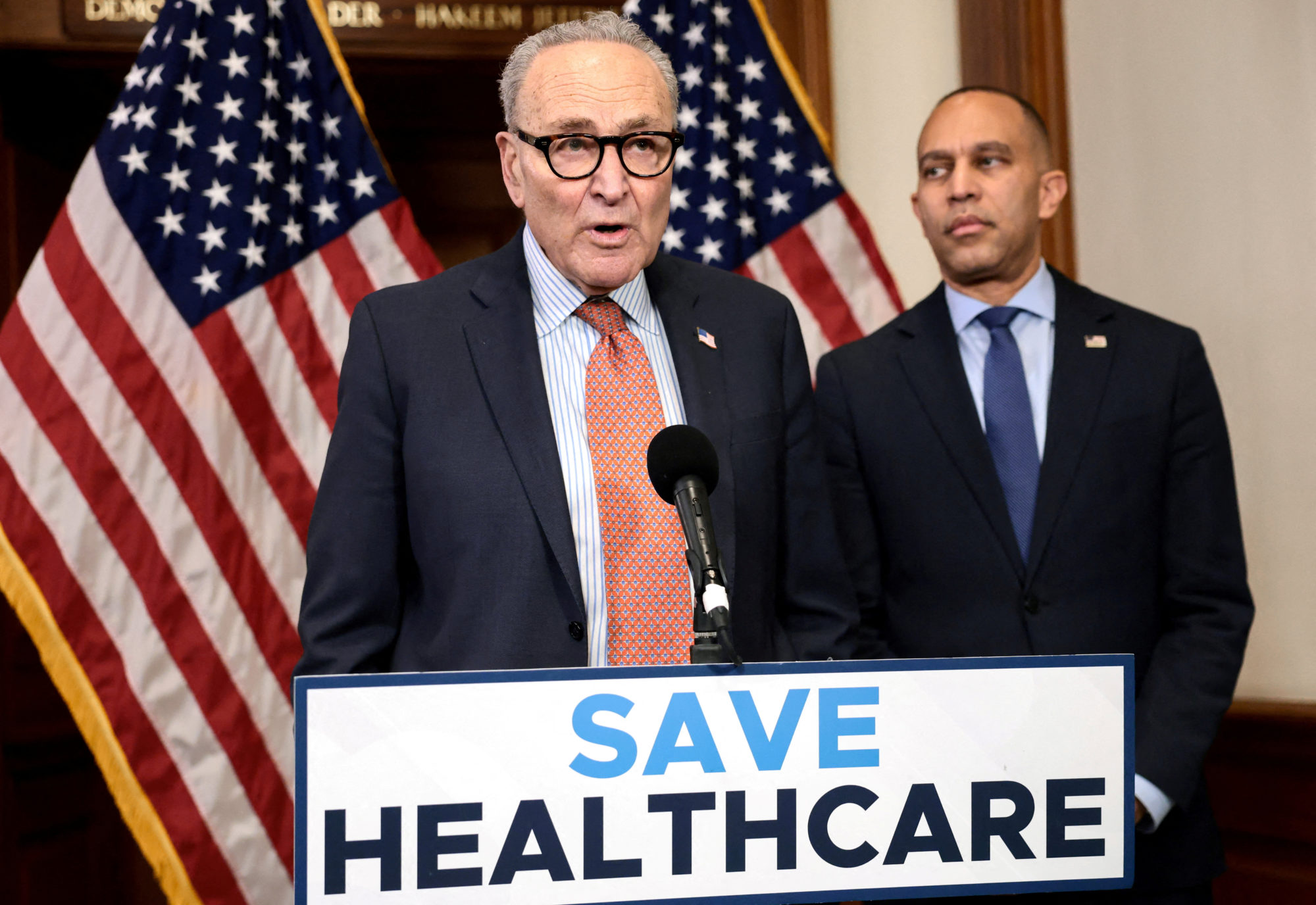 Senate Minority leader Chuck Schumer, D-N.Y., and House Minority Leader Hakeem Jeffries, D-N.Y., stand at a lectern with a sign that reads, SAVE HEALTHCARE.