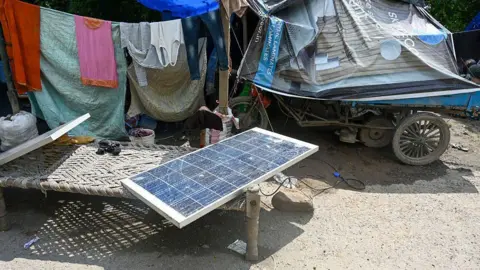 Hindustan Times via Getty Images OIDA, INDIA - SEPTEMBER 4: Flood-affected residents on Noida's Pushta Road installed solar panels in their homes to cope with the darkness, on September 4, 2025 in Noida, India. 
