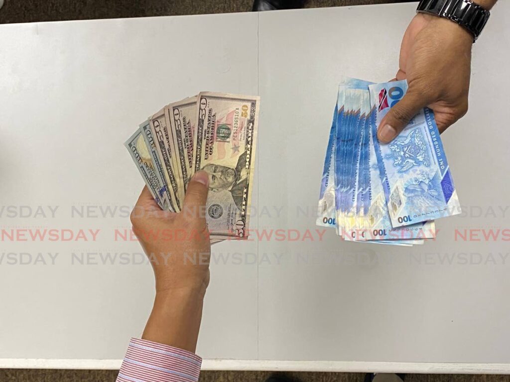 A cash transaction of TT dollars, right, for scarce US currency, left, amid the ongoing forex crunch. FILE PHOTO - 