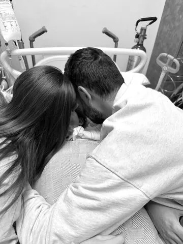 Melissa Mae Carlton/Instagram Melissa Mae Carlton and her husband, Tom Carlton, embrace their daughter Molly in a hospital bed
