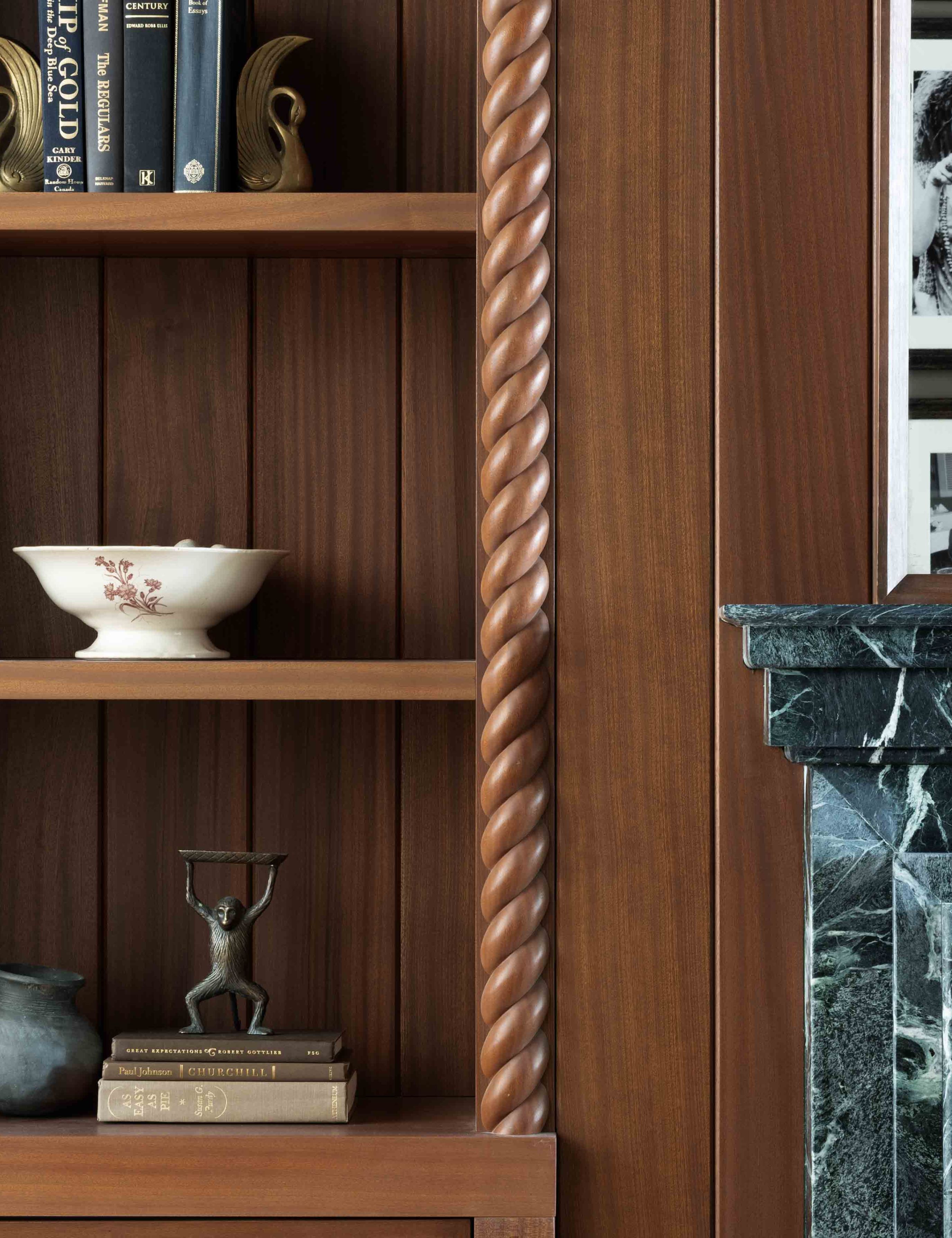 Parlor room wall shelf featuring warm spiraling wooden millwork and assorted antique objects