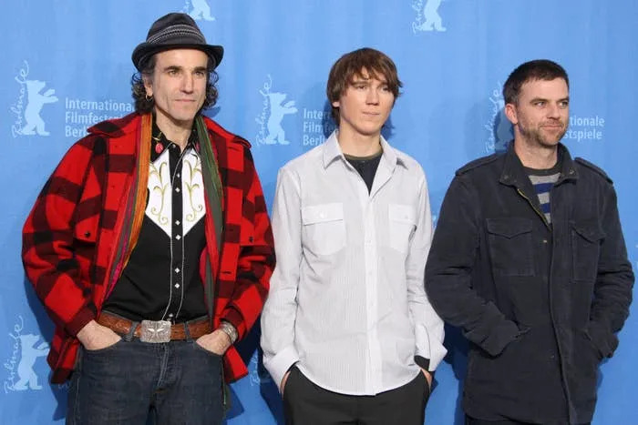 Three men stand together at a film event, wearing casual to semi-casual attire. The backdrop indicates the Berlinale Film Festival