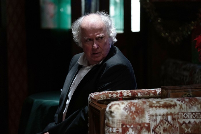 Nigel Bates, played by Paul Bradley sits in the dark Queen Vic and looks over his shoulder in EastEnders.