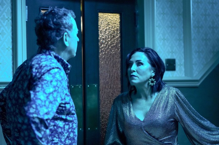 Kat and Alfie have a chat in the Queen Victoria hallway, which is tinted with a cold, blue light in a scene from EastEnders