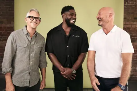 Netflix Gary Lineker, Micah Richards and Alan Shearer stand in a row indoors, smiling