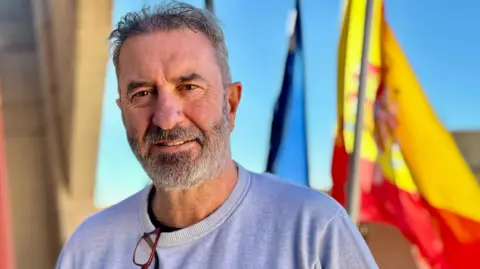 Luis Bertol Moreno, mayor of the Spanish town of Figueruelas stands in front of a Spanish flag