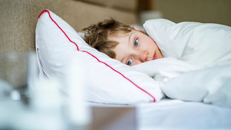 A stock photo of a child sick in bed