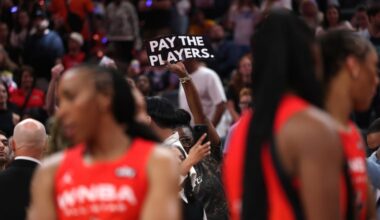 A fan holds a sign saying "Pay the players" during the 2025 WNBA All-Star Game. Especially in this era of legalized sports betting, there's never been more scrutiny on WNBA players, who argue that their compensation isn't commensurate with that of their male counterparts.