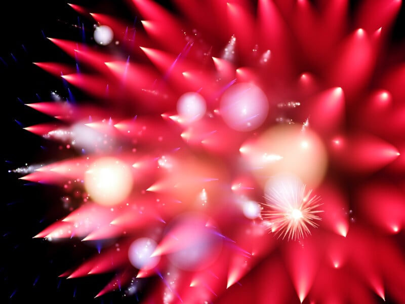 Bright red and pink bursts of fireworks with white and yellow glowing orbs and sparkling effects against a black night sky, creating a vibrant and dynamic display.