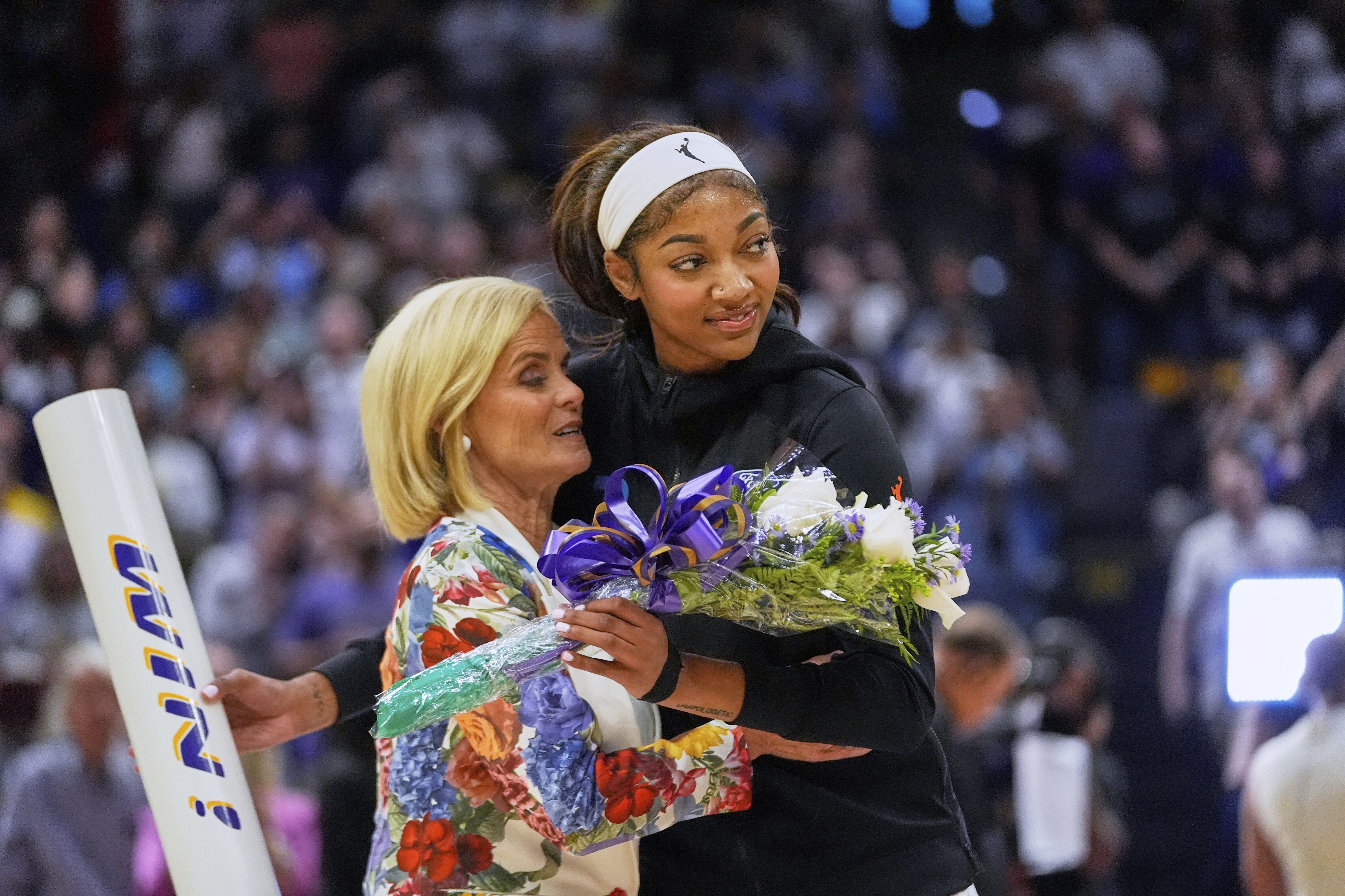 Sky forward Angel Reese hugs her former coach, LSU's Kim...