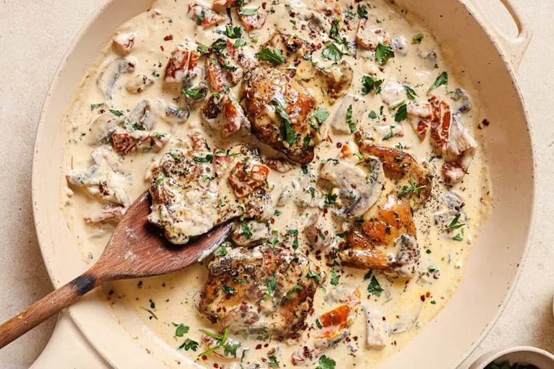 Chicken with creamy mushroom sauce in a pan.