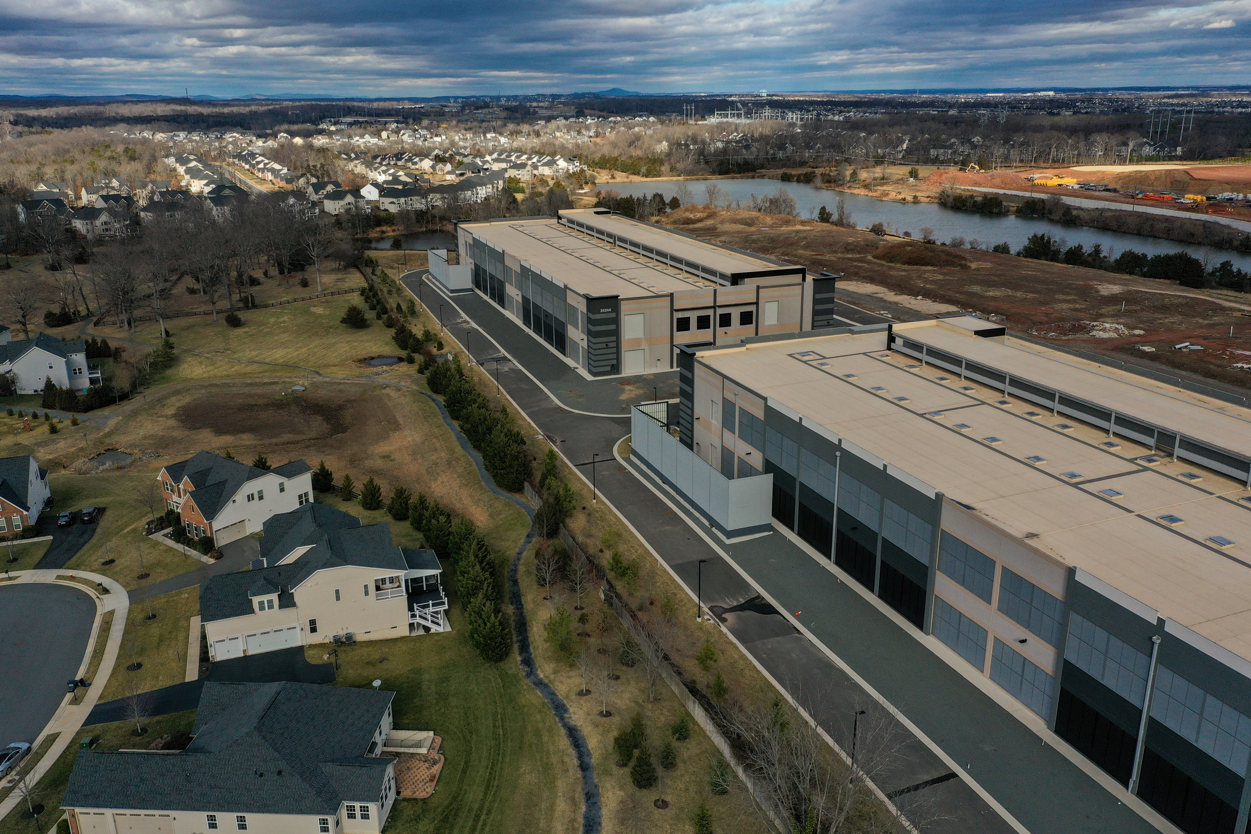 Amazon data centers are seen next to Loudoun Meadows houses in Aldie, Va. Credit: Jahi Chikwendiu/The Washington Post via Getty Images
