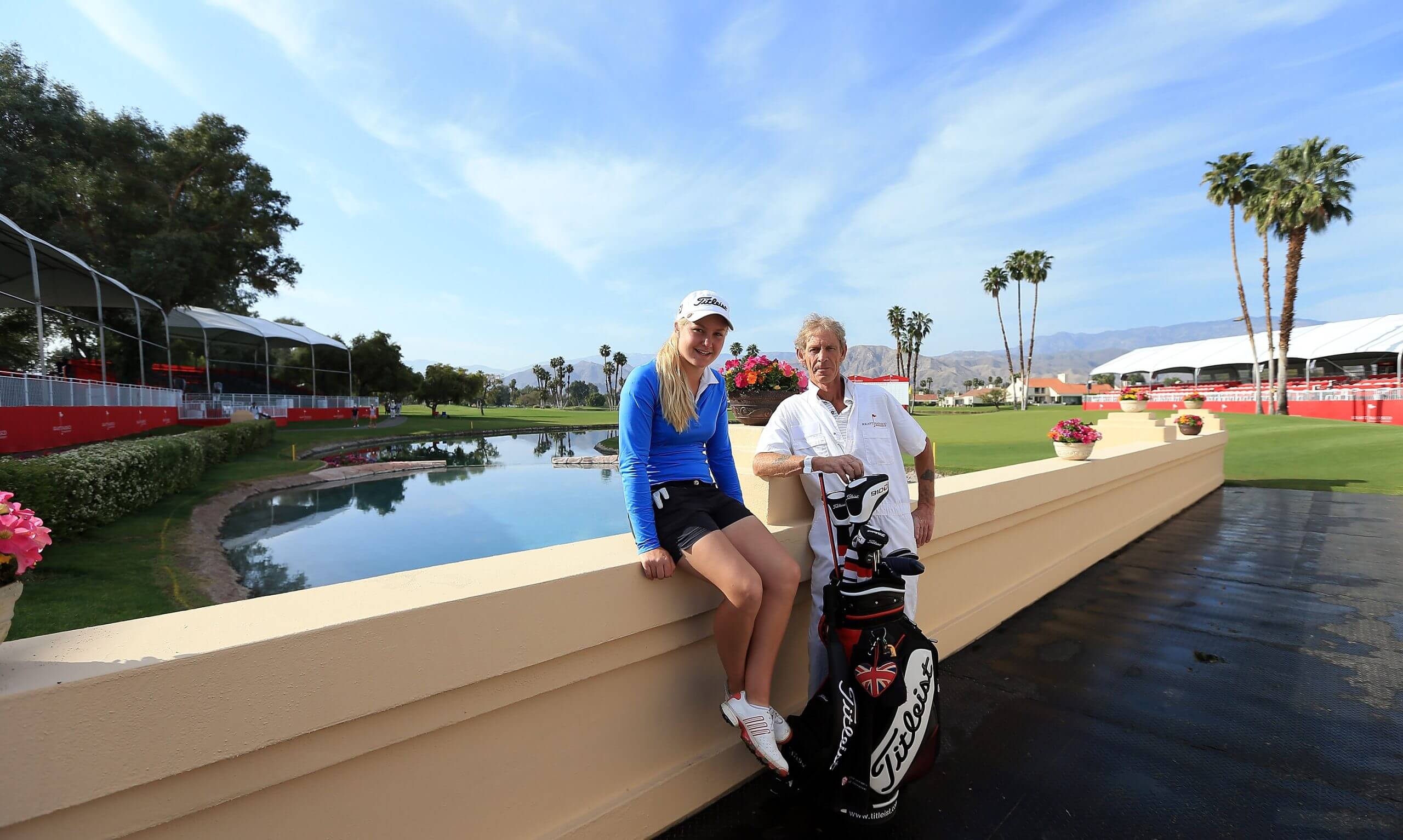 Charley Hull rests on the bridge at the 2012 Kraft Nabisco Championship, posing for a photo with her father, Dave.