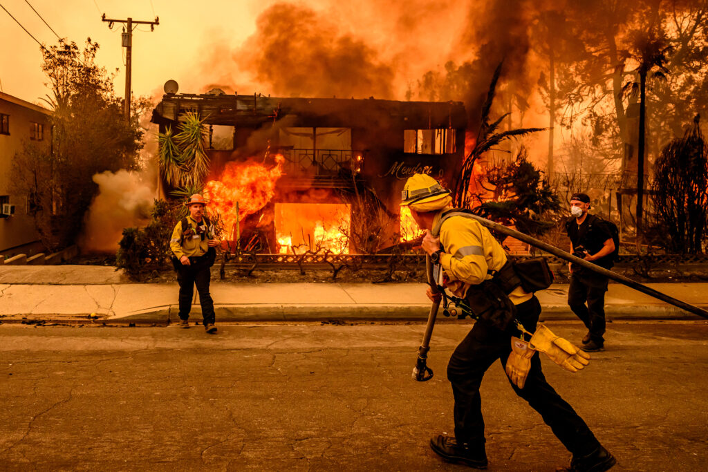 Firefighters work to extinguish flames as an apartment building burns during the Eaton Fire in Altadena on Jan. 8. Credit: Josh Edelson/AFP via Getty Images