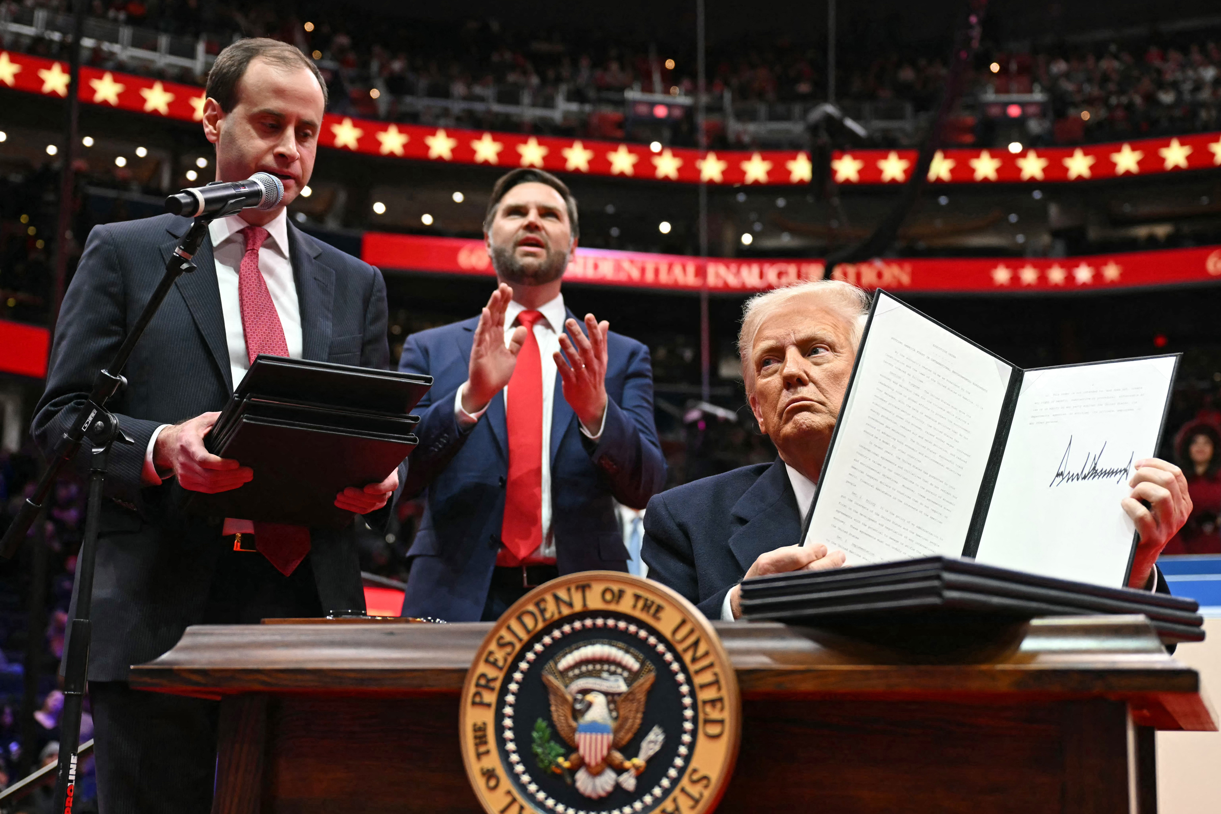 President Donald Trump holds his signed executive order announcing the U.S. withdrawal from the Paris Agreement during the inaugural parade inside Capital One Arena on Monday in Washington, D.C. Credit: Jim Watson/AFP via Getty Images