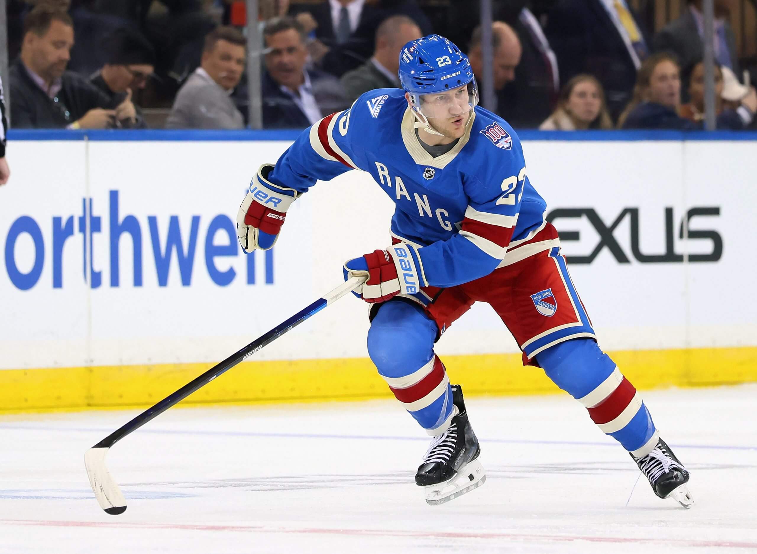 Adam Fox skates down the ice wearing the Rangers' centennial jersey.