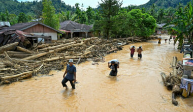 People wade through floodwater in the aftermath of flash floods on Dec. 2 in Central Tapanuli, North Sumatra. Credit: Yt Hariono/AFP via Getty Images