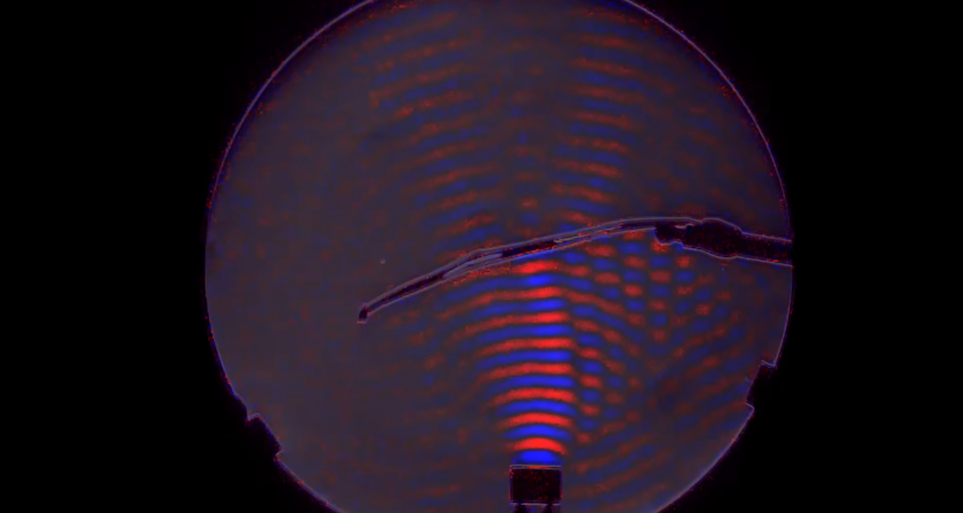 A red and blue visualization of the waves from a small ultrasonic speaker