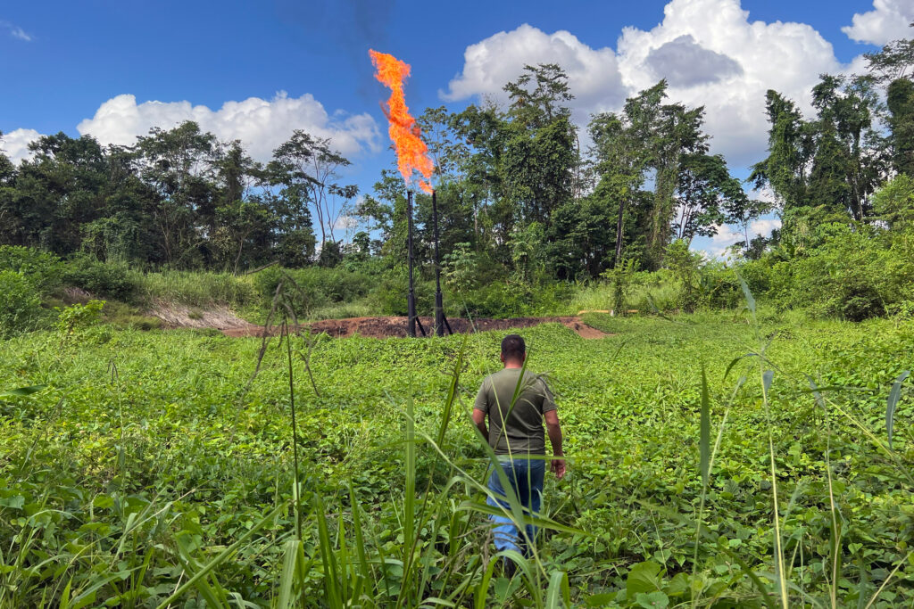 Donald Moncayo, president of the Union of Peoples Affected by Chevron-Texaco, walks toward a gas flare in the Ecuadorian Amazon region. Credit: Katie Surma/Inside Climate News