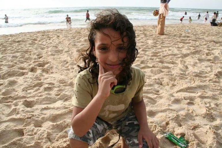 Young woman in cap and gown on a football pitch