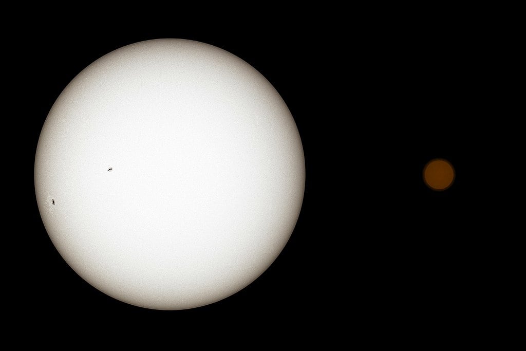 True colour illustration of the Sun (left) next to TRAPPIST-1 (right). TRAPPIST-1 is darker, redder, and smaller than the Sun.