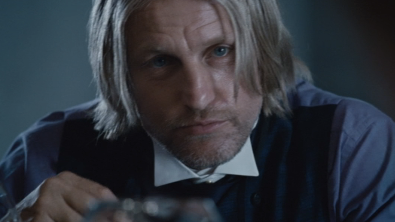 Woody Harrelson as Haymitch looking ahead while having dinner with Effie and the tributes in Hunger Games