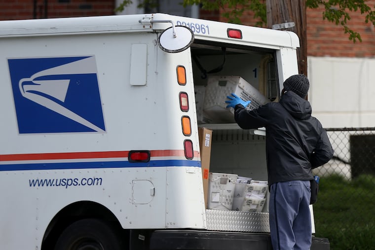 A U.S. Postal Service worker stops at a collection box on Secane Drive in Northeast Philadelphia in April 2020.