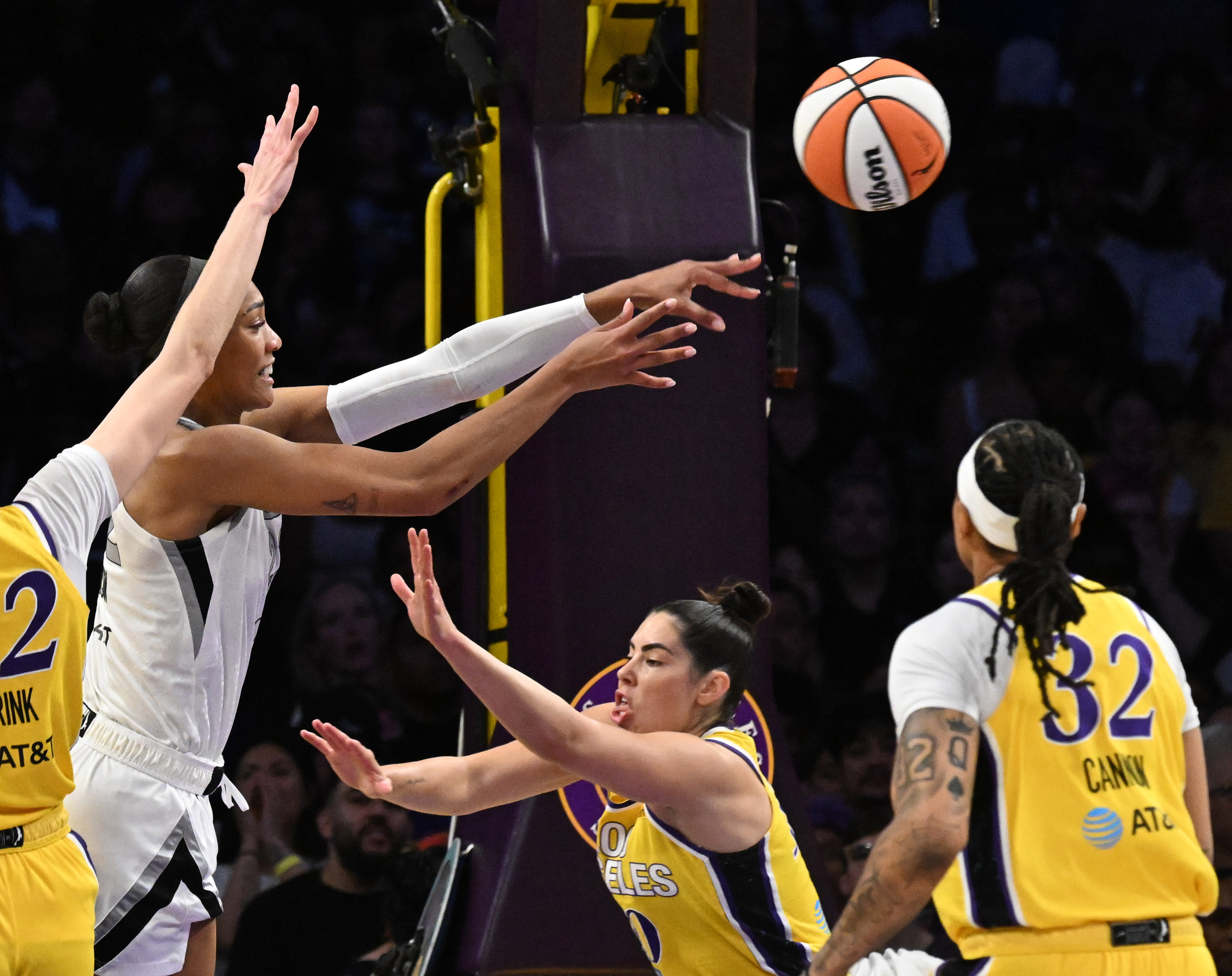 Las Vegas Aces center A’ja Wilson, left, passes the ball...