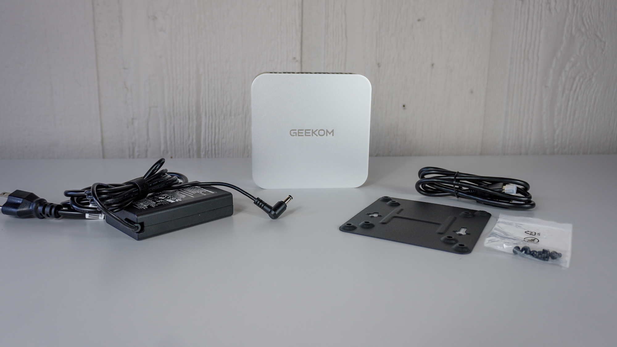 The Geekom A9 Max unboxed with all of its accessories on a table