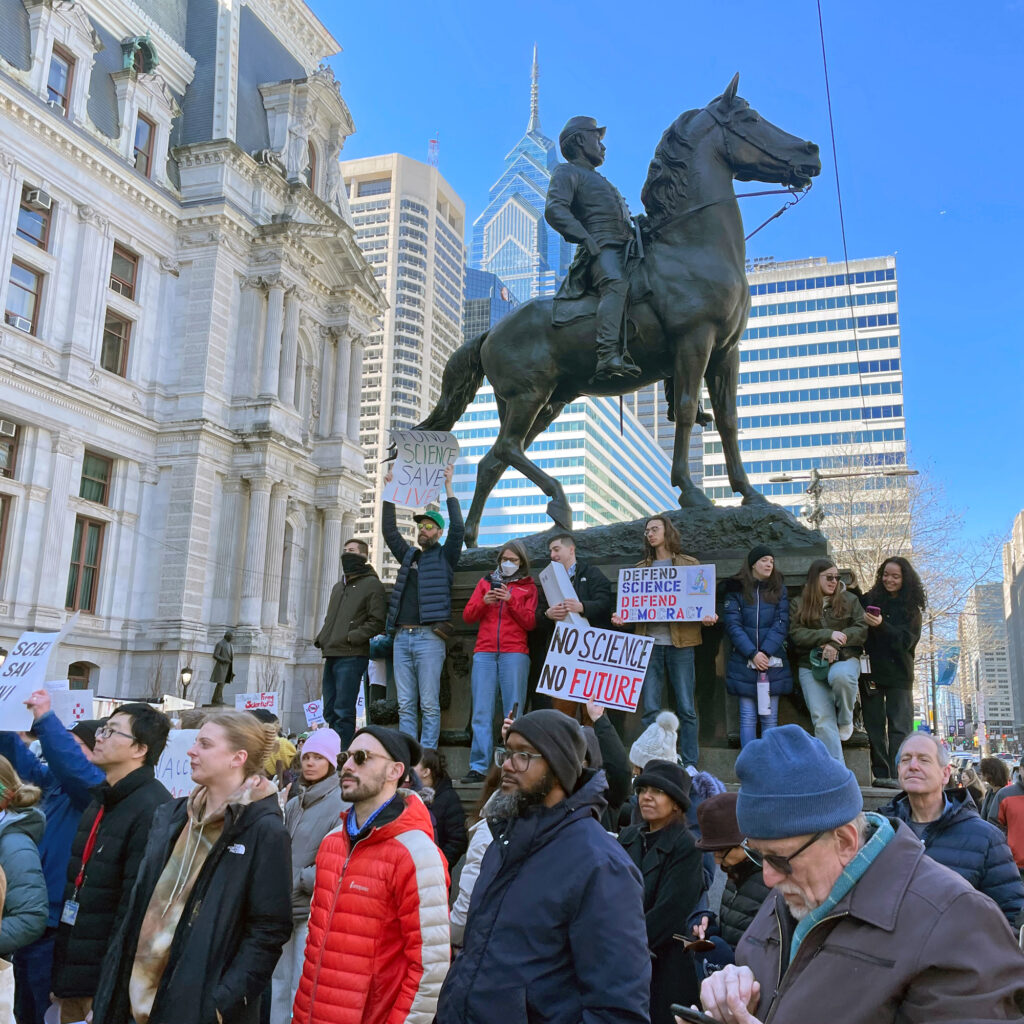 Protesters outside Philadelphia’s City Hall watch speeches during a Stand Up for Science rally on March 7. Credit: Kiley Bense/Inside Climate News