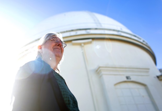 Lick Observatory astronomer Elinor Gates stands outside the damaged dome housing a 36-inch Lick Refractor telescope on Monday, Dec. 29, 2025, in San Jose, Calif.  A large metal shutter was torn off the dome during a recent wind storm.  (Aric Crabb/Bay Area News Group)