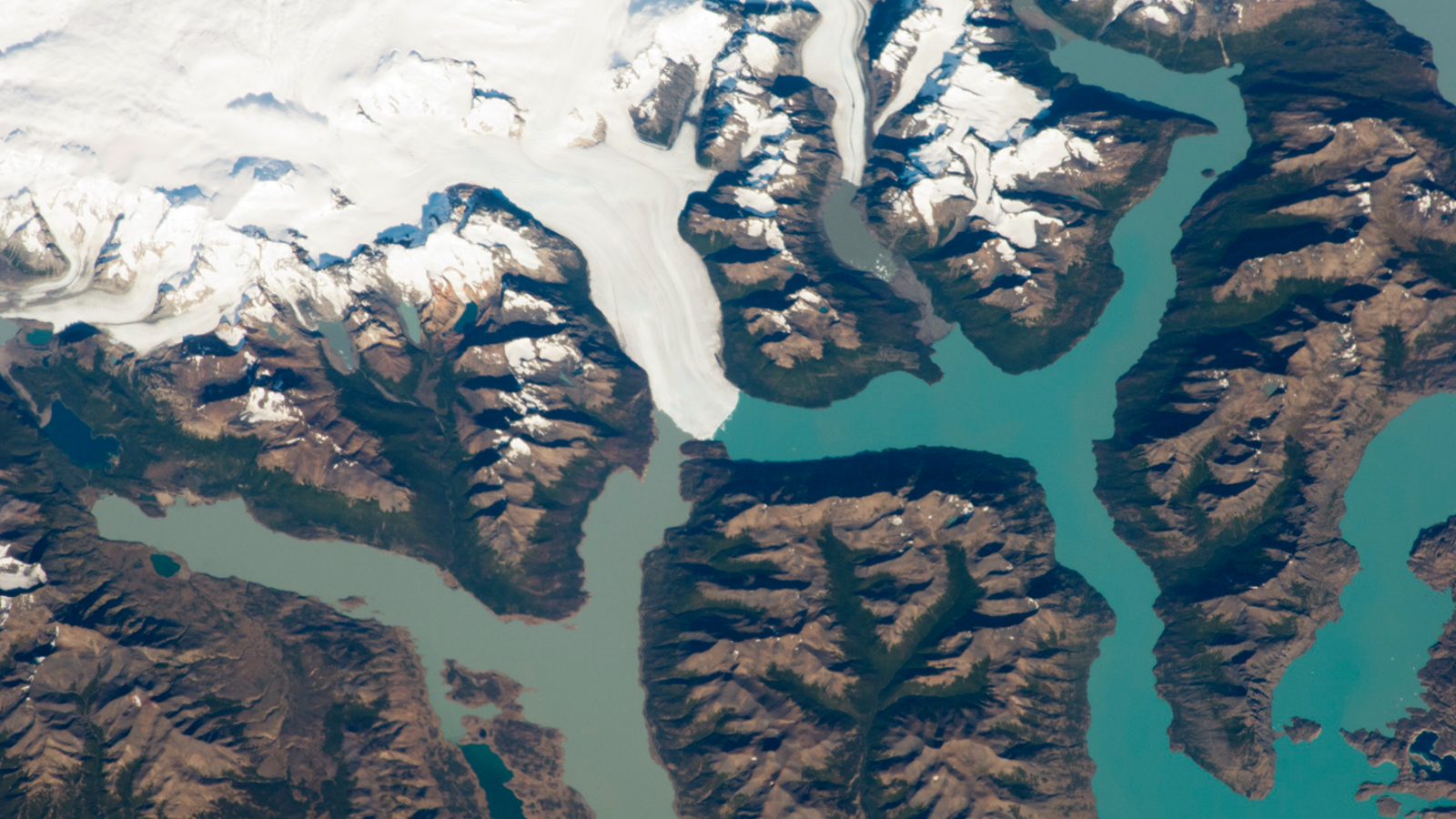 A zoomed-out astronaut photo of the wider glacier, lake and river systems