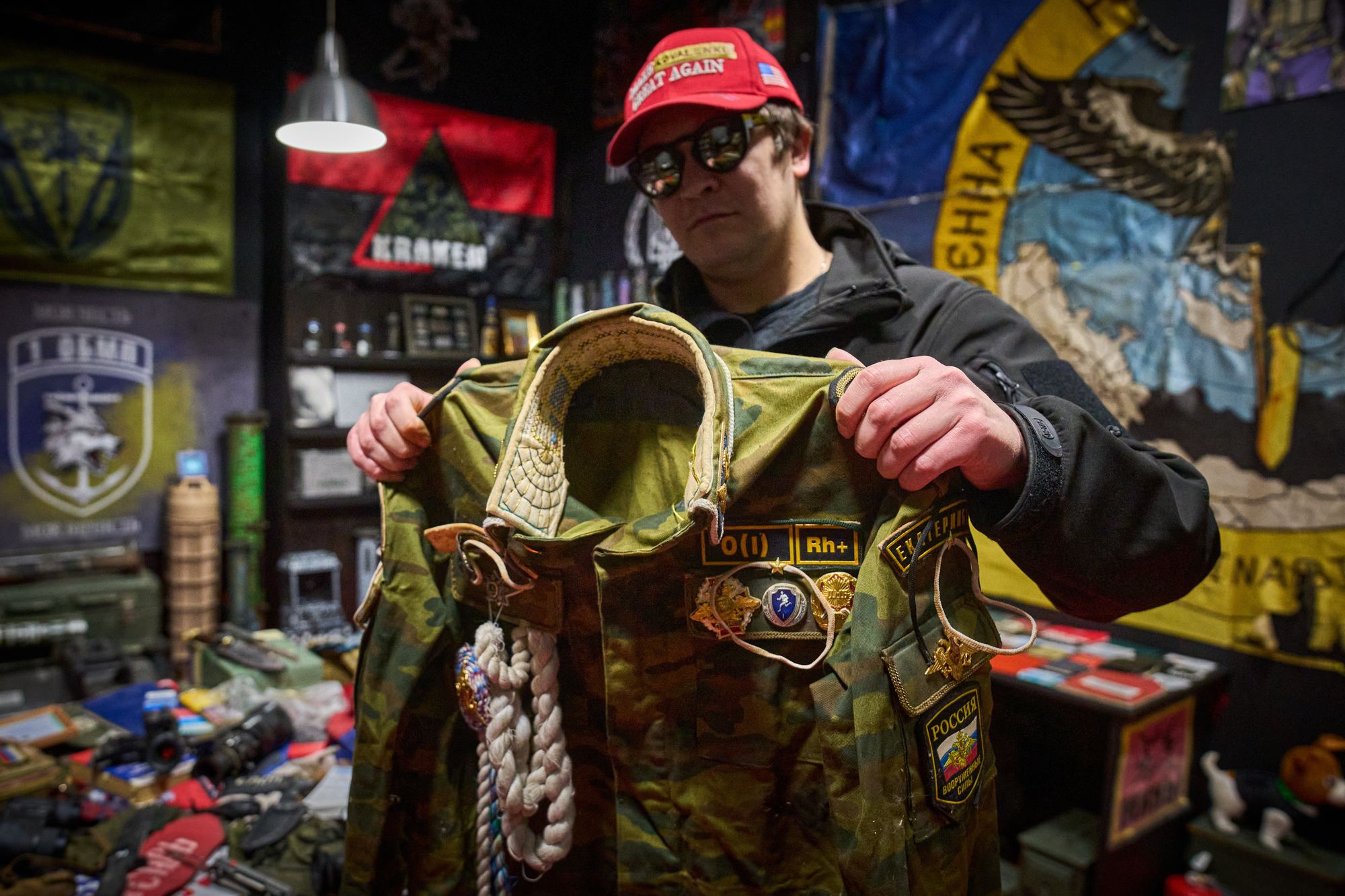 Ukrainian street artist Maxim Kilderov holds a Russian ceremonial uniform in his private museum