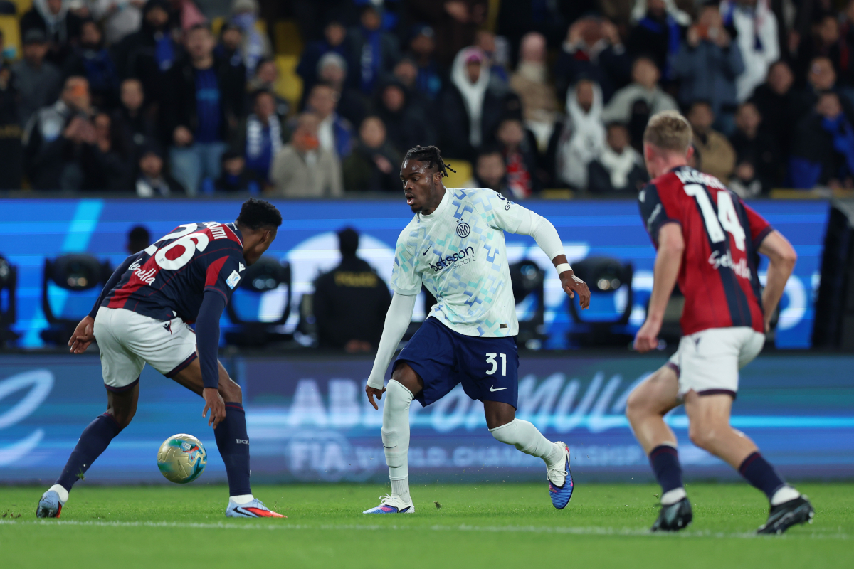 RIYADH, SAUDI ARABIA - DECEMBER 19: Yann Aurel Bisseck of Internazionale runs with the ball past Jhon Lucumi of Bologna FC 1909 during the Supercoppa Italiana semifinal match between Bologna FC 1909 and FC Internazionale at King Saud University Stadium on December 19, 2025 in Riyadh, Saudi Arabia. (Photo by Yasser Bakhsh/Getty Images)
