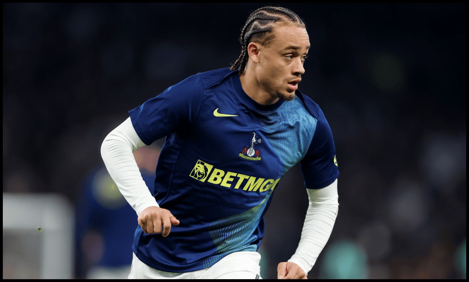 Xavi Simons runs while warming up for Tottenham.