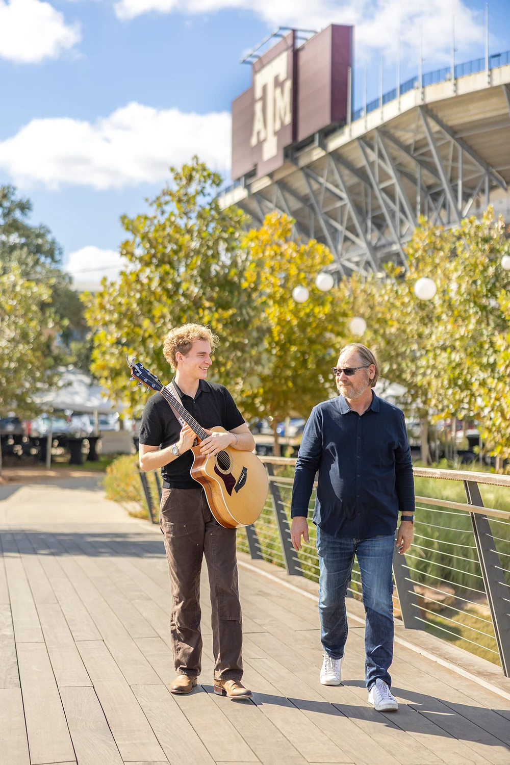 Portrait of Aiden Ross walking across a bridge with his father